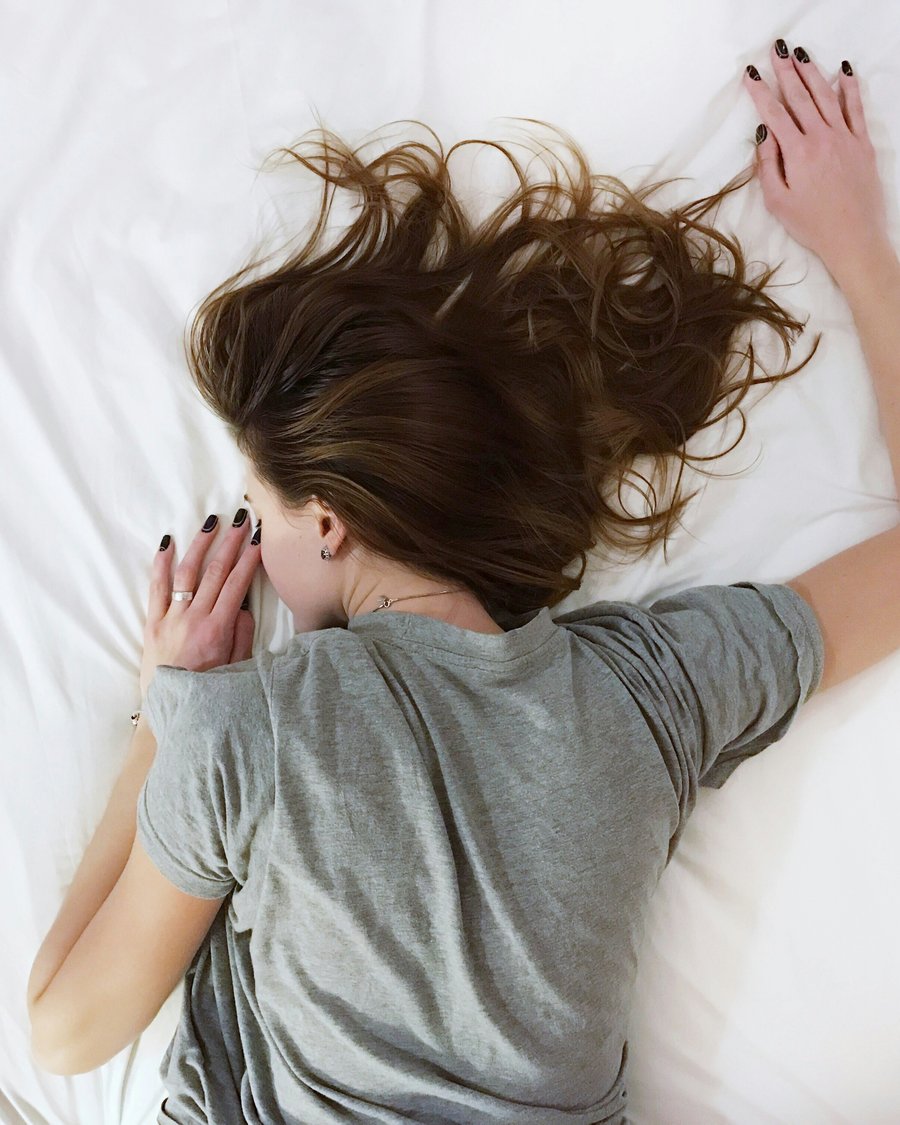 A person sleeping peacefully in soft white bedding