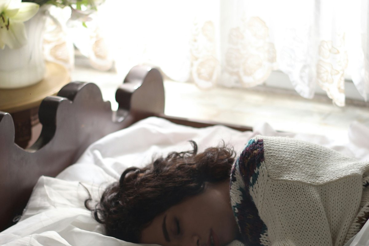 A cozy bed with warm light at night